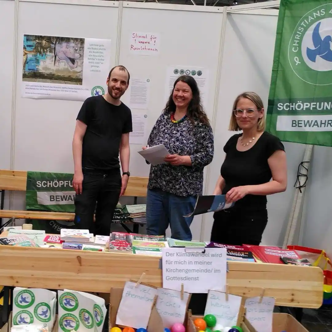 Das Bild zeigt drei Aktivisti an einem Infostand der Christians for Future.
